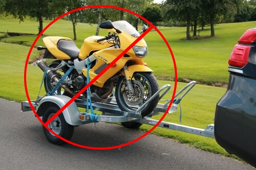 Moto Honda VTR 100 amarilla sobre un trailer con símbolo de prohibido